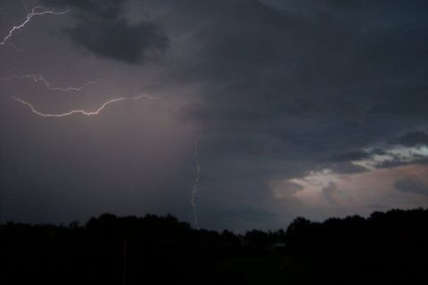 1979 Ford Bronco - A dramatic lightning storm illuminates the dark sky above a silhouetted treeline.
