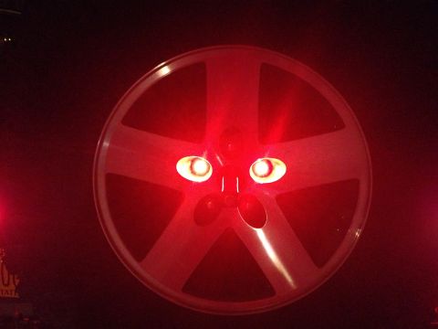 2005 Jeep Wrangler - This red third brake light features a five-spoke design and two illuminated bulbs, resembling a face.