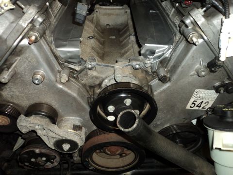 2004 Mercury Grand Marquis - Close-up of a V8 engine, showing pulleys, belts, and a label with the number 542.