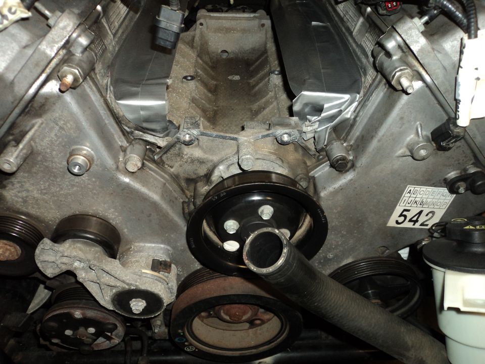 V8 engine with pulleys and hoses, label with '542' visible