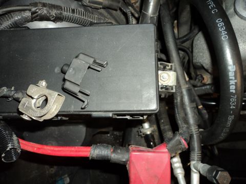 2004 Mercury Grand Marquis - Close-up view of engine bay components including a fuse box, battery terminals, and a Parker hose with visible text.