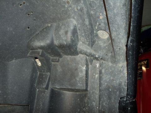 2004 Mercury Grand Marquis - This is a close-up view of a vehicle's inner fender liner, showing its molded plastic construction and mounting hardware.