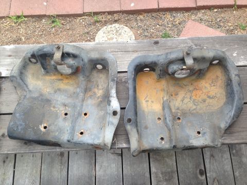 1986 Ford Bronco - Pair of used metal brackets, likely for a vehicle, shown on a wooden surface.