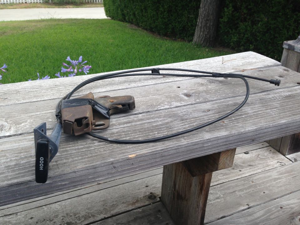 Hood latch release lever with 'HOOD' text and cable assembly