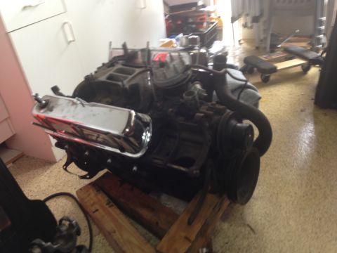 1986 Ford Bronco - Engine part on wooden supports in a garage setting.