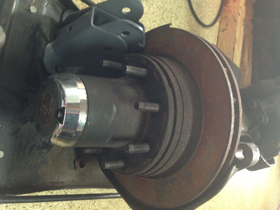 Close-up of a Ford Bronco hub assembly with a chrome cap and a rusty brake rotor