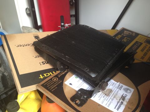1986 Ford Bronco - Radiator part shown on top of cardboard boxes, with some text visible on the boxes.