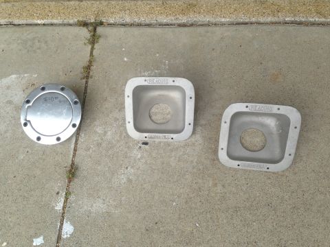 1986 Ford Bronco - Three aluminum parts, possibly for a truck body, are laid out on a concrete surface.