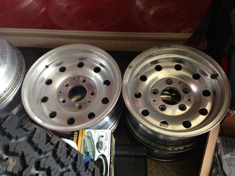 Two aluminum alloy wheels with 5x5.5 bolt pattern and a section of a mud-terrain tire