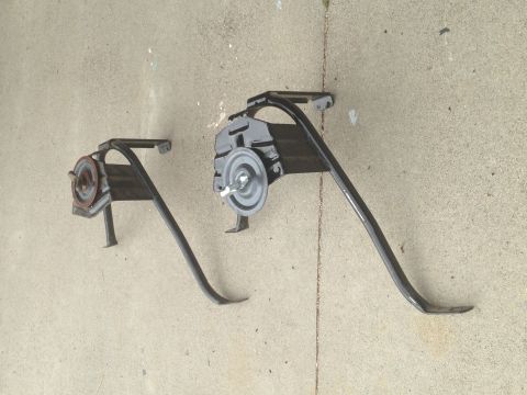 1986 Ford Bronco - Two vehicle jack components are shown resting on a concrete surface.