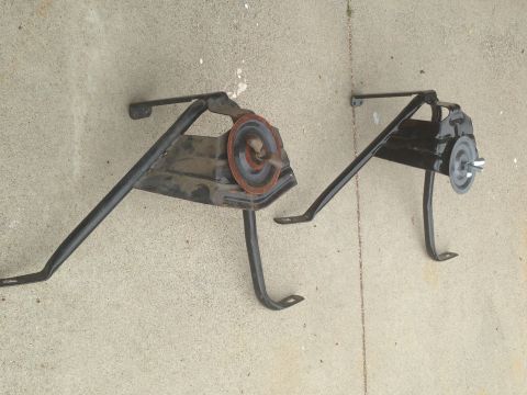 1986 Ford Bronco - Two black metal brackets, possibly for a vehicle, are shown mounted on a concrete surface.