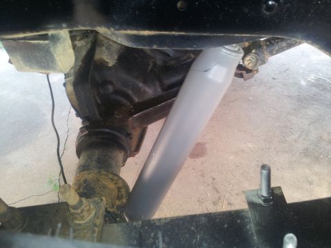 1988 Ford Bronco - Close-up view of a vehicle's rear axle assembly and a gray shock absorber.