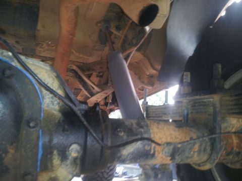1988 Ford Bronco - Close-up of a vehicle's rear axle and shock absorber, showing suspension components.