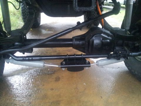 1988 Ford Bronco - The underside of a vehicle reveals its suspension and drivetrain components.
