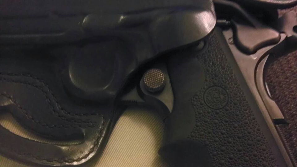 Close-up of a black gun in a leather holster