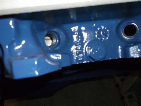 1967 Ford Mustang - Close-up of a blue painted engine block casting, showing part numbers and mounting holes.