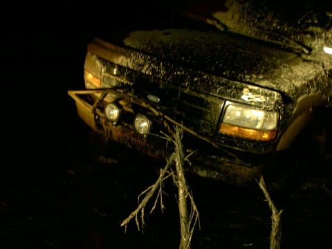 1995 Ford Bronco - This 1995 Ford Bronco appears to be stuck in mud, with branches obscuring the front.
