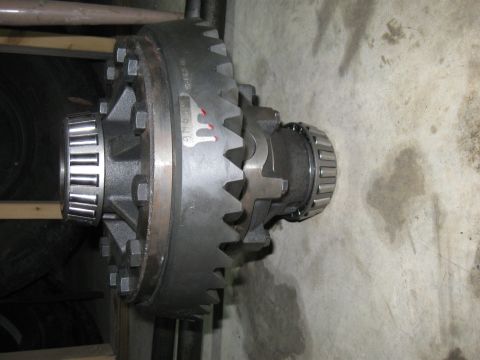 1990 Ford Bronco - Close-up of a vehicle differential assembly, including gears and bearings, on a concrete floor.