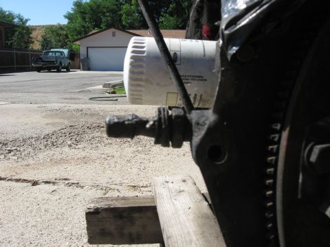1981 Ford Bronco - Engine part and oil filter in focus, with a pickup truck visible in the background.