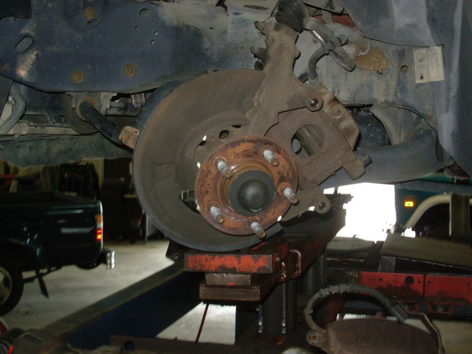 I didn't get to take a lot of pics because I was rushing to get done so the car didn't sit on a working rack at a friend's shop, and because my hands were so filthy.  But it was pretty straightforward, other than the springs.  The only other significant snag was the brake caliper hoses...

I got the later hoses with the calipers, but I didn't realize the fittings were a different size, so my old hard frame lines wouldn't connect.  And when I tried to put the old lines on the new calipers, I found they were bent wrong at the caliper ends to mate up.  So I had to swap sides with the hoses to get them to connect.  No leaks so far...
UPDATE: Still no leaks after 3 years...

Disc Removal 

1. Raise vehicle on hoist. 
CAUTION: Use care to avoid damage to the front disc brake rotor (1125) and nicking, scratching, or contamination of the brake shoe and lining (2001) .
2. Remove the wheel and tire assembly from the wheel hub (1104) . Be careful to avoid damage to or interference with the bleeder screw and front disc brake rotor shield (2K004) . 
3. Remove two caliper anchor plate bolts and discard. 
4. Remove the front disc brake caliper (2B120) & anchor plate (2B292) assembly from the front wheel spindle (3105) and rotor . 
5. If the front disc brake caliper does not require servicing, it is not necessary to disconnect the front brake hose (2078 ). Position the front disc brake caliper out of the way, and support it with a wire to avoid damaging the disc brake caliper or stretching the front brake hose . 
6. Mark the front disc brake rotor and lug bolt position to aid assembly.
7. Punch out the mandrels from the rotor-to-hub rivets. 
8. Using a 9.5-mm (3/8-in.) drill, remove the heads from the rotor-to-hub rivets.
CAUTION: Use care to avoid rotor damage while drilling. 
9. Remove the front disc brake rotor from the wheel hub.
CAUTION: If excessive force is used to remove the front disc brake rotor , the rotor total indicated runout (TIR) must be checked. Refer to Section 06-00 . 

NOTE: If the front disc brake rotor does not come off easily, apply Rust Penetrant and Inhibitor F2AZ-19A501-A or equivalent meeting Ford specification ESR-M99C56-A, then strike the front disc brake rotor between the lug bolts with a soft-faced hammer. 

10. If necessary, remove any remaining chips or rivet sleeves. 

Installation 
NOTE: Rotor machining is not necessary for minor scoring or lining material buildup. 

1. Clean the hub mounting surface of the front disc brake rotor as well as the hub mounting surface for rust, scale or dirt. The contamination will not allow front disc brake rotor to sit flat to the hub surface. 

If the front disc brake rotor is being replaced, remove the protective coating from the new front disc brake rotor with Metal Brake Parts Cleaner (Non-Chlorinated) F5AZ-2C410-AA or equivalent. 

Lubricate the hub mounting surface with High Temperature Nickle Anti-Seize Lubricant F6AZ-9L494-AA or equivalent meeting Ford specification ESE-M12A4-A prior to installing the front disc brake rotor . 
2. Align the painted match marks and position the front disc brake rotor assembly on the wheel hub . 
3. Rivet the front disc brake rotor to the wheel hub . 
4. Install disc brake caliper / front disc brake caliper anchor plate assembly onto front disc brake rotor . 
5. Install two new caliper anchor plate mounting bolts and tighten to 170-230 Nm (125-169 lb-ft).
6. Install wheel and tire assembly, using Rotunda Accutorq® Lug Nut Sockets 164-R0303 or equivalent on 1/2 inch drive air impact wrench or torque wrench to tighten lug nuts to 115-142 Nm (85-104 lb-ft). 

CAUTION: Failure to tighten lug nuts (1012) in a star pattern can result in high rotor runout, which will speed up the development of brake roughness, shudder and vibration. 

Check rotor total indicated runout (TIR). Refer to Section 06-00 . 
7. Lower vehicle. 
8. Pump brake pedal (2455) several times to position brake shoes and linings . 
9. Road test vehicle.