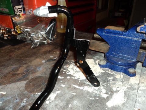 2004 Mercury Grand Marquis - A modified metal pipe assembly is secured in a vise on a workbench, with various parts in the background.
