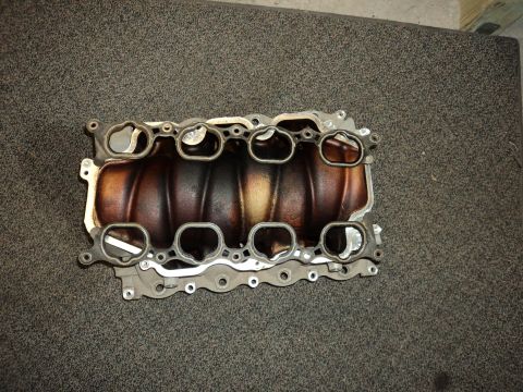 2004 Mercury Grand Marquis - An intake manifold is shown on a textured surface, with a Supermotors.net logo in the corner.