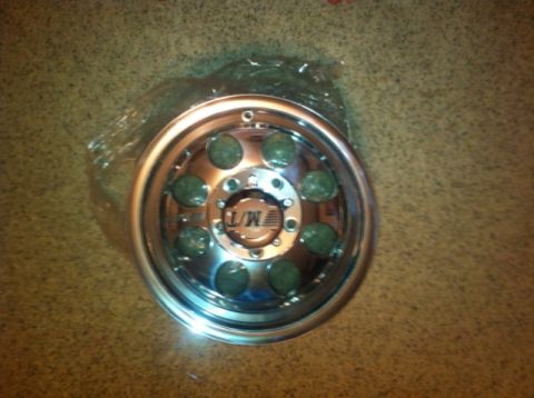1982 Ford Bronco - A single chrome wheel with green inserts is shown, the L/M logo in the center.