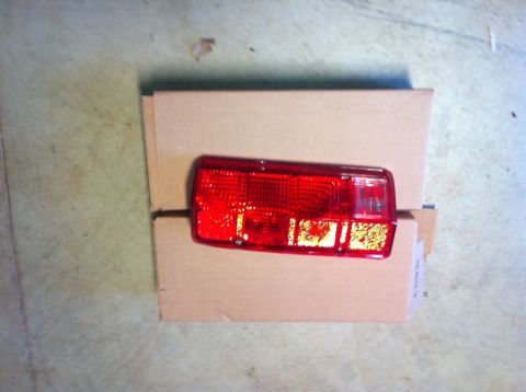 1982 Ford Bronco - A red taillight assembly is shown against a cardboard box, with a Supermotors.net watermark at the bottom right.