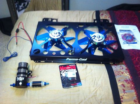 1982 Ford Bronco - Perma-Cool electric fan assembly and Holley fuel pump shown laid out on a bed.