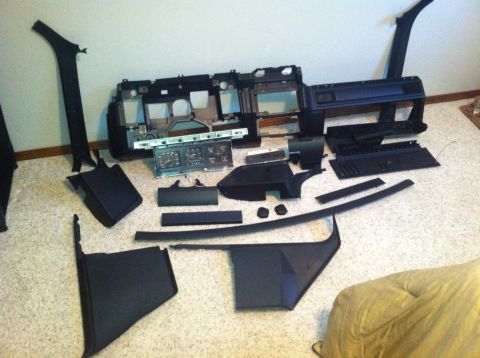 1982 Ford Bronco - Interior parts, including dashboard and instrument cluster, are spread out on the floor.