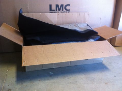 1982 Ford Bronco - A carpet kit is shown inside an open cardboard box with "LMC TRUCK" visible on a larger box behind it.