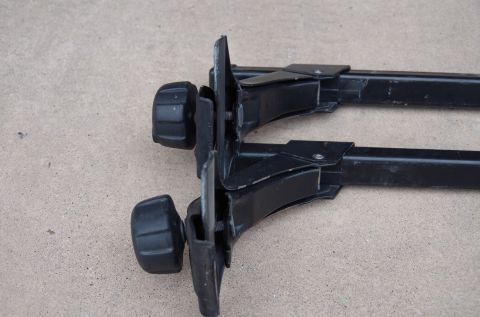 1983 Ferrari Enzo - Close-up of black Thule roof rack mounting hardware, showing the adjustable knobs and metal brackets.
