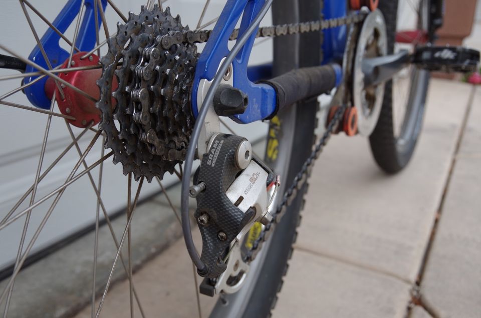 Rear derailleur and cassette on a blue bicycle frame