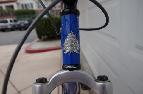 1983 Ferrari Enzo - Close-up of a blue bicycle's head tube an Intense Racing logo and Tioga Alchemy headset.