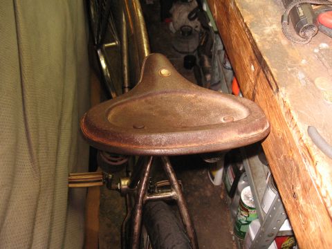 1994 Ford Bronco - A close-up of a weathered bicycle seat, showing its metallic texture and springs underneath.