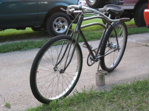 1994 Ford Bronco - A vintage bicycle with a unique frame design is shown outdoors, with two trucks in the background.