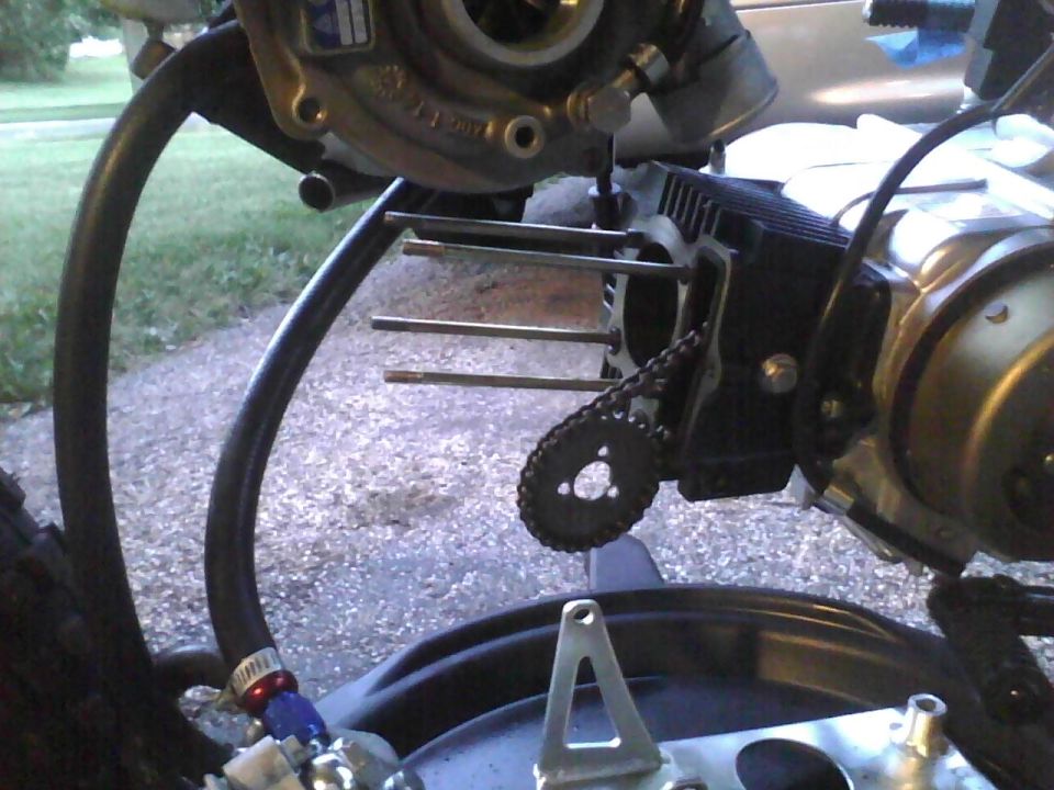 Motorcycle engine part with chain and bolts