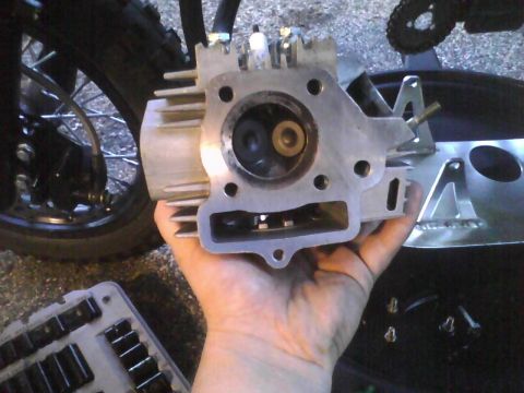 2003 Ford Crown Victoria - Close-up of a motorcycle engine cylinder head being held by a hand.