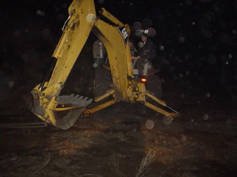 1995 Ford Bronco - Backhoe loader operating in the dark with two people visible in the cab.