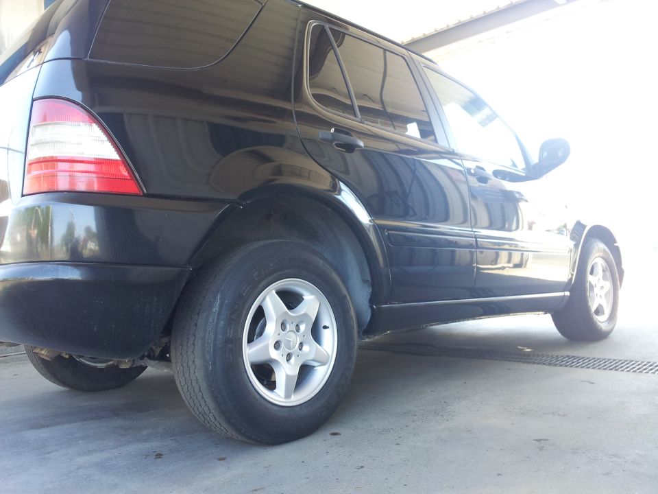 Black Mercedes-Benz ML-Class SUV, side view showing rear wheel and door
