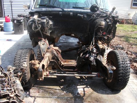 1990 Ford Bronco - The chassis of a 1990 Ford Bronco is shown from the front, with the engine and some body panels removed.