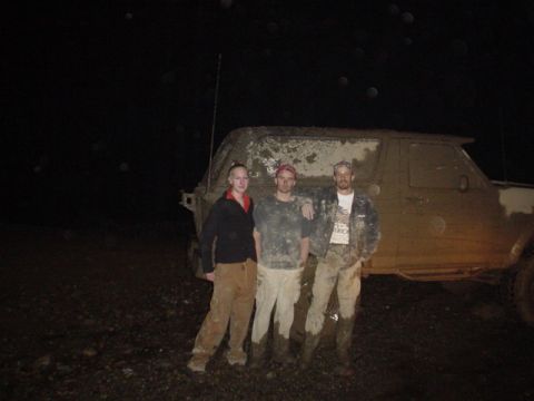 1995 Ford Bronco - Three people pose in front of a mud-covered SUV at night, suggesting an off-road adventure.