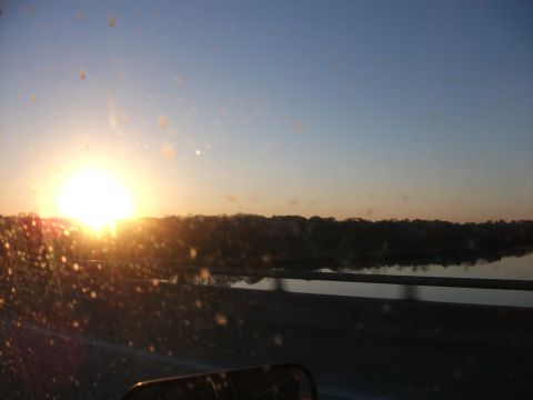 1990 Ford Bronco - Sunset view from a vehicle, with water and trees visible.