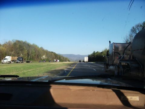 1990 Ford Bronco - View from inside a vehicle on a highway, with several trucks visible in the distance and along the roadside.