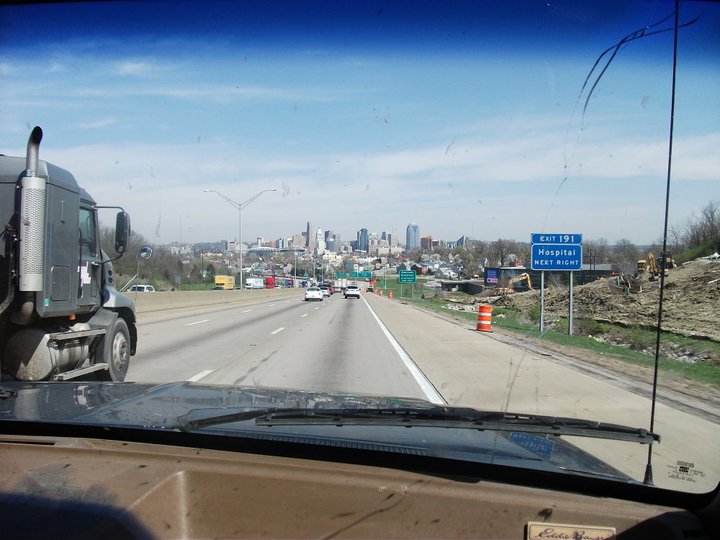 Highway scene with truck, city skyline, and exit sign