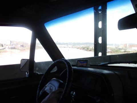1990 Ford Bronco - View from inside a vehicle looking out at a river and city skyline.