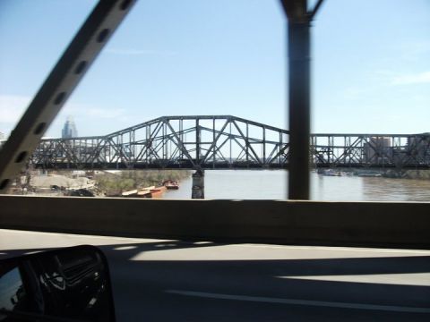 1990 Ford Bronco - Reflection in a side mirror shows a vehicle driving over a bridge with a river below.