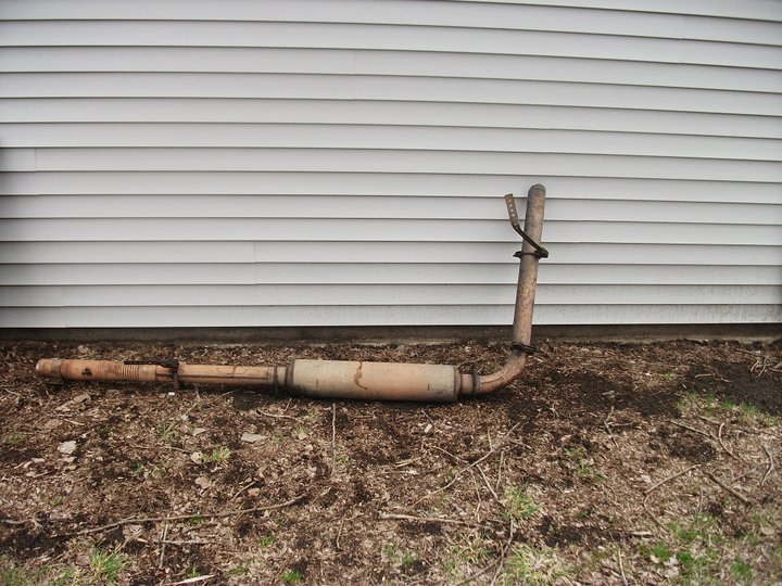 exhaust pipe and muffler lying on the ground