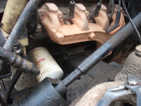 1990 Ford Bronco - Close-up view of an engine bay, highlighting an oil filter and exhaust manifold with a Ford logo.
