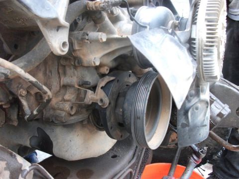 1990 Ford Bronco - Close-up view of an engine's fan and pulley system, showing mechanical components.